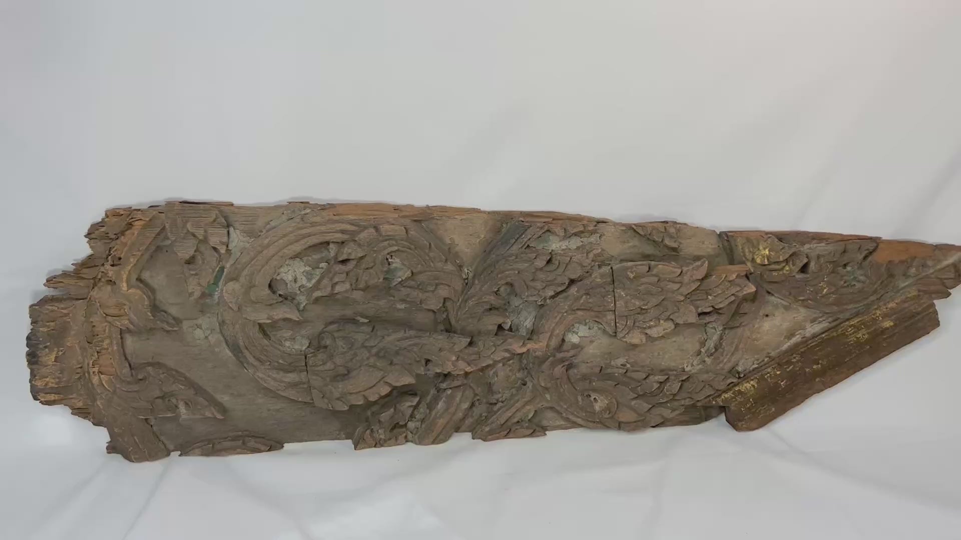 17th-century Thai Ayutthaya carved wooden temple fragment with flowing motifs, remnants of gilding, and symmetrical sacred design.