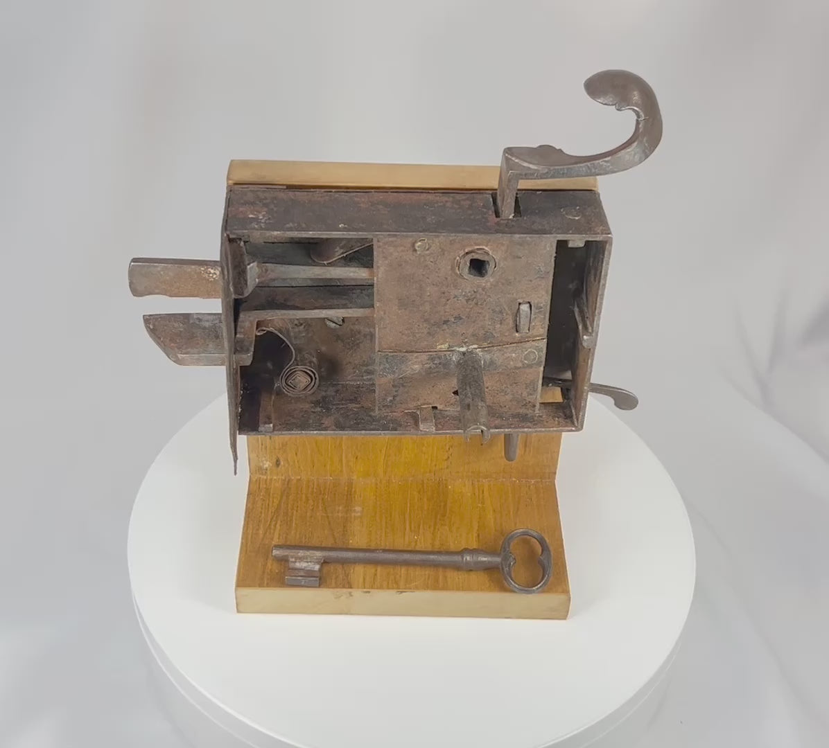 360° rotating view of a 19th century iron door lock mechanism with exposed internal components and multi-bolt system