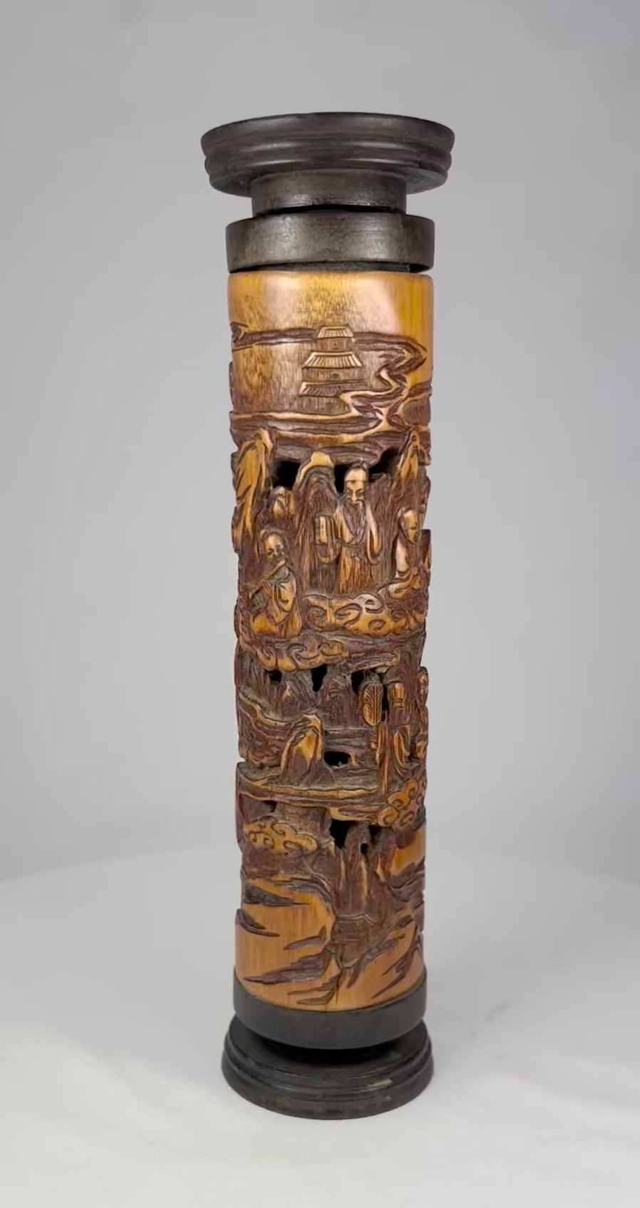 Late 19th-century Chinese boxwood incense holder, intricately hand-carved with detailed landscape and figure scenes, cylindrical form with dark-stained end caps; showcases fine Qing-era craftsmanship in wood carving for ritual and domestic use.