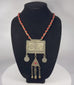 Antique Turkmen tribal necklace featuring a large rectangular pectoral pendant, triangular tumar amulet, silver-toned metal, red glass beads, suspended coin elements, and handcrafted Central Asian ceremonial craftsmanship dating to the late 19th or early 20th century.