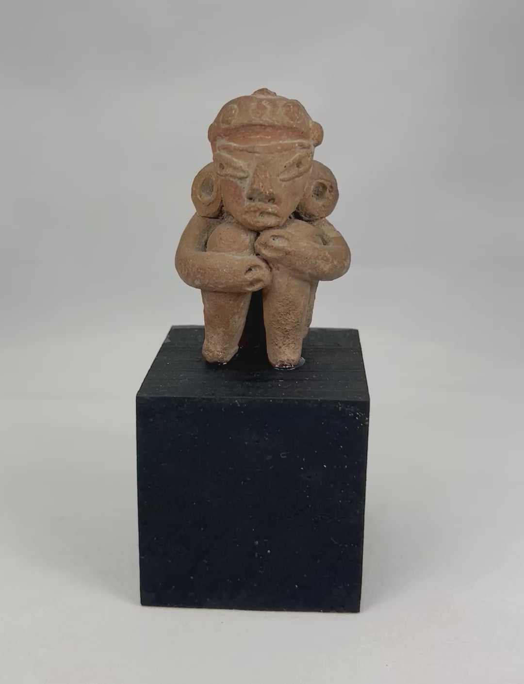 360-degree interactive view of a Pre-Columbian West Mexican terracotta seated figure showing wrapped-arm posture, stylized facial features, ear ornaments, and authentic ancient patina