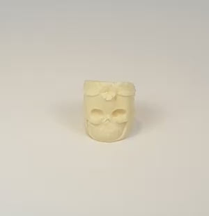 360-degree view of hand-carved camel bone skull ring with floral decoration, sculptural details, and natural bone texture