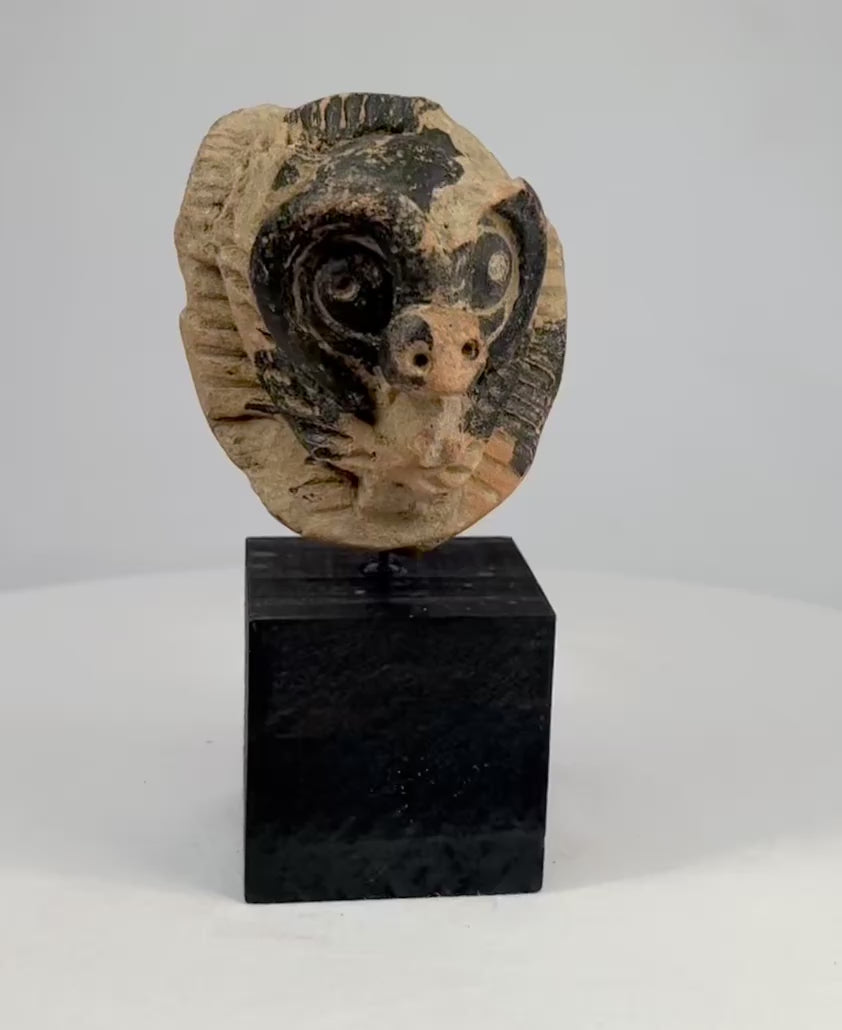 Pre-Columbian terracotta mask fragment from Mesoamerica, Classic Period (500–900 AD), depicting an animal face with bold eyes and snout, incised patterns, and traces of black pigment.