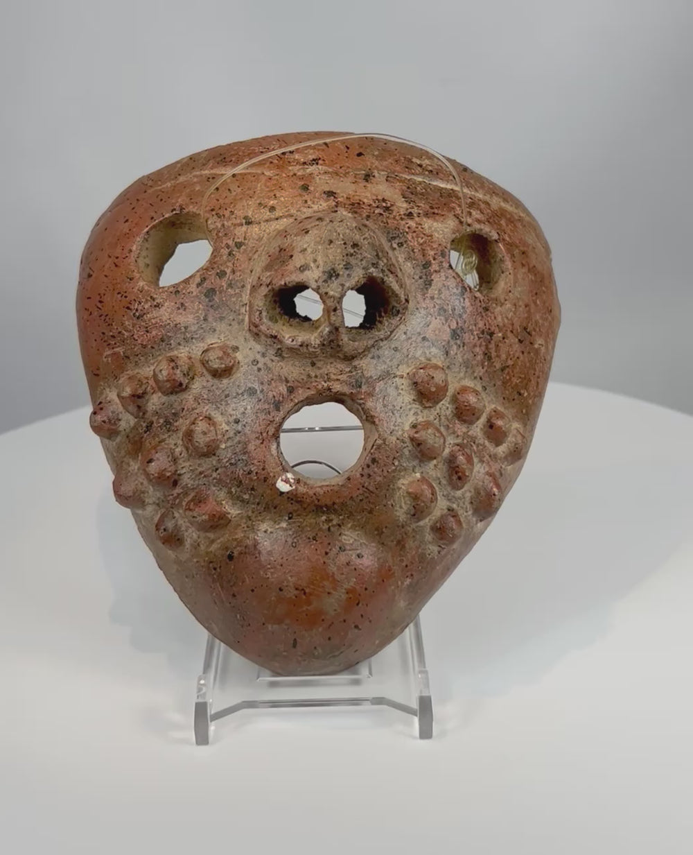 Video showcasing Pre-Columbian terracotta mask with perforated eyes nodular decoration and aged burial patina from multiple angles