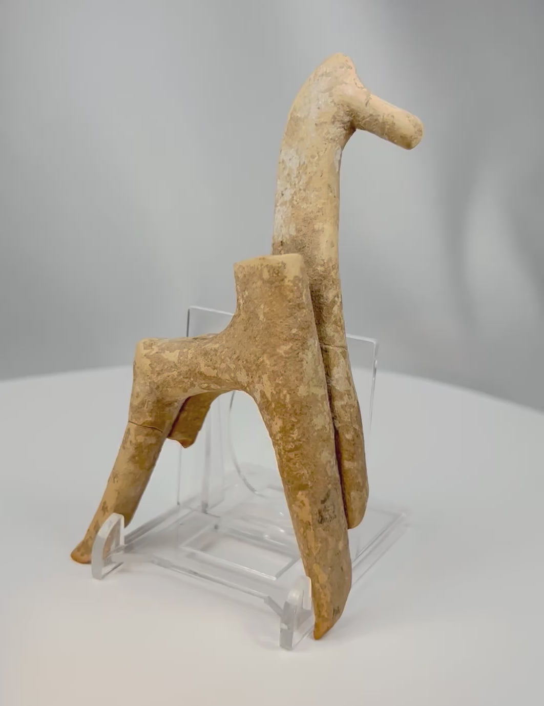 360-degree view of an ancient Greek terracotta horse votive from Boeotia showing stylized geometric form and archaeological patina.