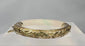 Rotating view of an antique Chinese hinged jade or hardstone bracelet with pale celadon colouring, natural green inclusions, repoussé floral silver mounts, a safety chain, and an interior SILVER mark