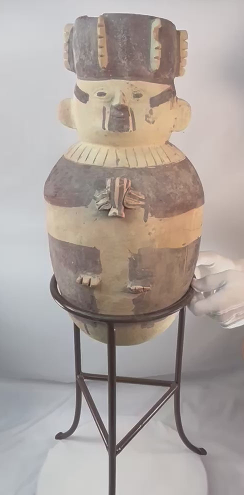 Large Chancay ceramic effigy urn from ancient Peru (1000–1400 CE), hand-sculpted terracotta vessel depicting a human figure with headdress and geometric painted motifs, Pre-Columbian artifact displayed on stand at Relic and Rarity.