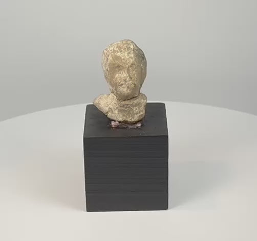 Video showcasing an ancient Greek mold-made terracotta protome with stylized facial features, hollow backless construction, and weathered archaeological surface