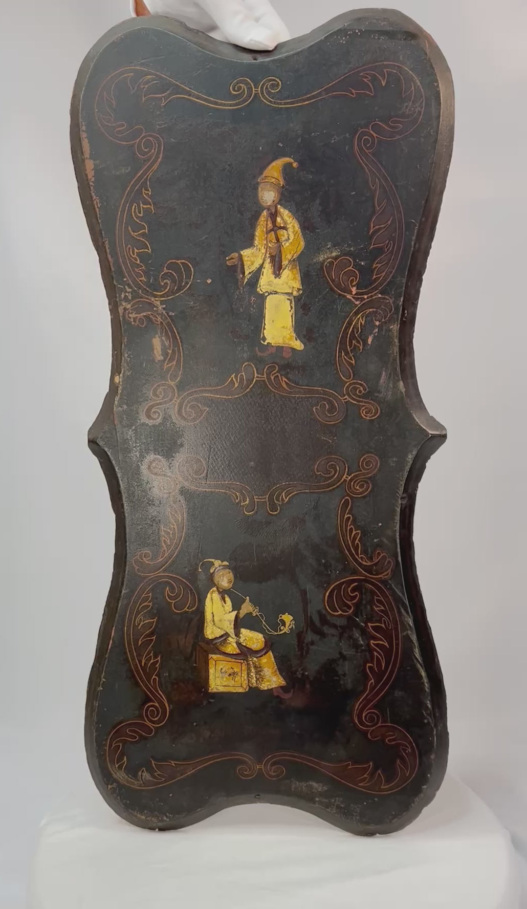 Pair of 19th-century Chinoiserie wall panels with hand-painted Asian-inspired figures, floral motifs, and gilt decoration on shaped black lacquered wood, circa 1850–1880.