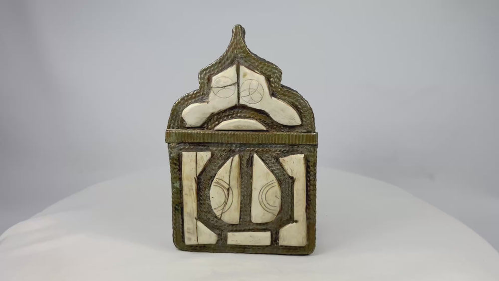 360-degree rotating view of a 19th century Moroccan Berber brass amulet box with carved bone inlay, pointed arch lid, geometric talismanic motifs, and aged patina.