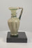 360-degree rotating view of an ancient Roman–Byzantine glass jug dating to the 4th–5th century CE, featuring pale green glass, vertical ribbing, a flared mouth, applied blue-green glass decoration, a curved handle, and extensive ancient surface patination.