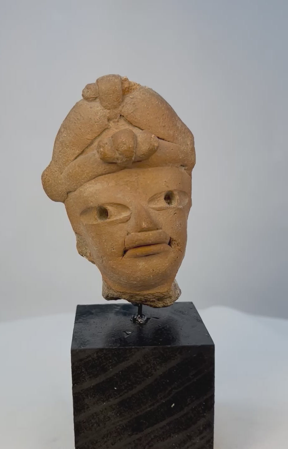 Full 360 display video of ancient terracotta head fragment mounted for exhibition