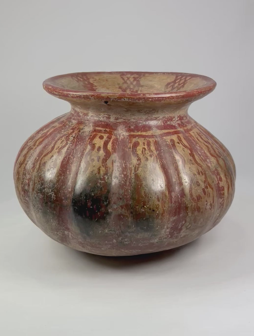 360-degree rotating view of a Pre-Columbian Moche-style globular ceramic vessel with red and beige painted surface patterns on a white background
