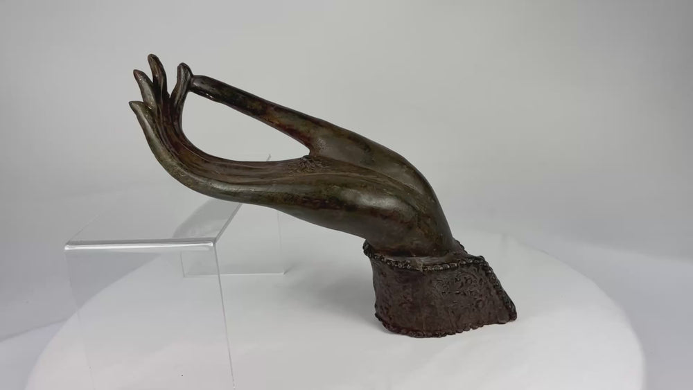 360-degree rotating view of an 18th–19th century Northern Thai/Lao bronze Buddha hand fragment showing elongated fingers, palm chakra emblem, and aged brown-olive patina.