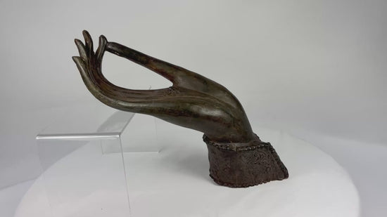Bronze Buddha hand fragment from 18th–19th century Northern Thailand or Laos with elongated fingers, palm rosette/chakra, original wrist cuff with beaded edge, rich brown-olive patina, traces of lacquer and earthen accretions, representing Abhaya or Vitarka mudrā in Lanna/Lan Xang Buddhist art.
