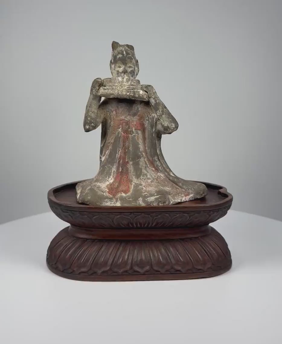 Ancient Chinese Tang Dynasty terracotta seated female musician dating to circa 618–907 CE, featuring a traditional multi-piped pan flute, flowing court robes, an elaborate hairstyle, traces of red and white mineral pigments, a naturally aged surface, and a carved wooden display stand.