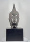 360-degree rotating view of a large 18-inch Thai bronze Buddha head attributed to the 19th-century Rattanakosin period, featuring Sukhothai-style spiral hair curls, a tall flame-shaped ushnisha, downcast eyes, elongated earlobes, a serene expression, dark metallic patina, and visible age-related wear and damage at the lower neck.