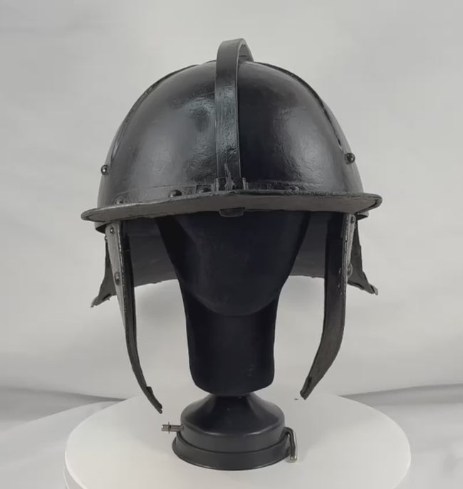 360-degree video of an authentic mid-17th century German or Dutch forged iron military helmet showcasing the fluted skull, adjustable nasal bar, articulated neck guard, ring finial, and original black painted finish.