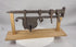 Rotating presentation of a large 18th-century European wrought-iron sliding hasp gate lock with riveted lock body and custom wooden stand