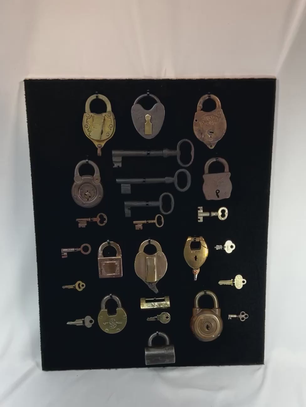 Close-up video showcasing antique padlocks and skeleton keys with slow zoom on individual locks, keys, and full framed display