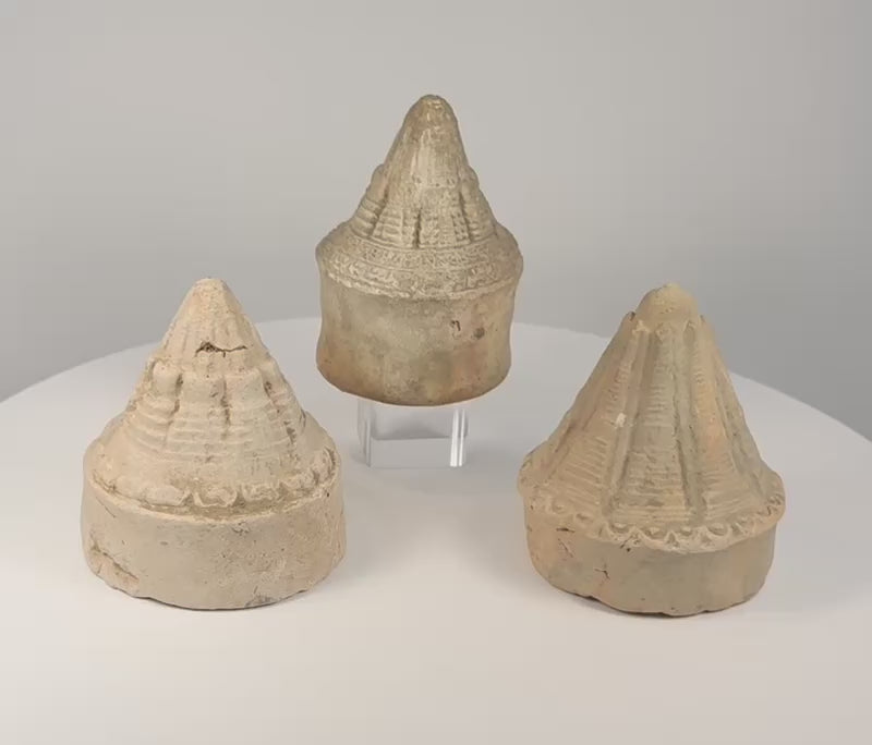 Three ancient Eastern Indian Buddhist terracotta votive stupas rotating to display their distinct moulded forms, ribbed spires, and aged surfaces
