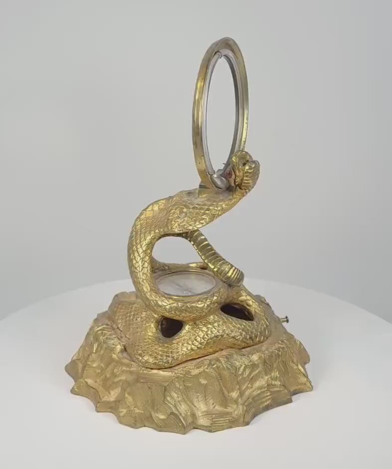 360-degree video showing a Victorian gilt bronze cobra inkstand designed by Benjamin Waterhouse Hawkins, featuring a coiled snake form, circular thermometer, compass, pocket-watch hook, pen holder, and detailed mid-19th-century decorative casting.