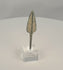 Rotating view of an ancient Western Asiatic bronze projectile point with an elongated lanceolate blade, pronounced raised central rib, long rectangular tang, rounded tip, green and blue-green patination, pale mineral encrustation, and a modern clear acrylic display base