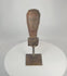 Rotating view of a Southeast Asian carved hardwood ceremonial figure fragment displaying expressive stylized facial features, weathered aged wood surface, traces of pigment, and mounted presentation on a custom metal display stand.