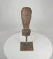 Rotating view of a Southeast Asian carved hardwood ceremonial figure fragment displaying expressive stylized facial features, weathered aged wood surface, traces of pigment, and mounted presentation on a custom metal display stand.