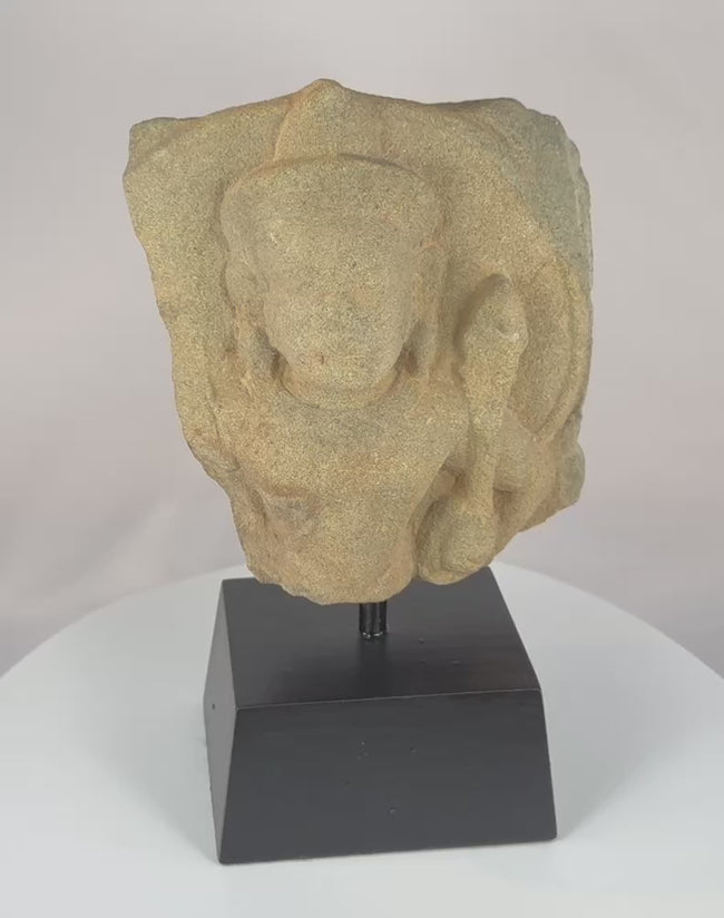 Video showing a 12th-century Khmer stone fragment depicting Padmapani Avalokitesvara from Cambodia, with serene facial features, refined Angkor-period carving, weathered stone surfaces, and preserved sculptural details associated with Buddhist devotional art.