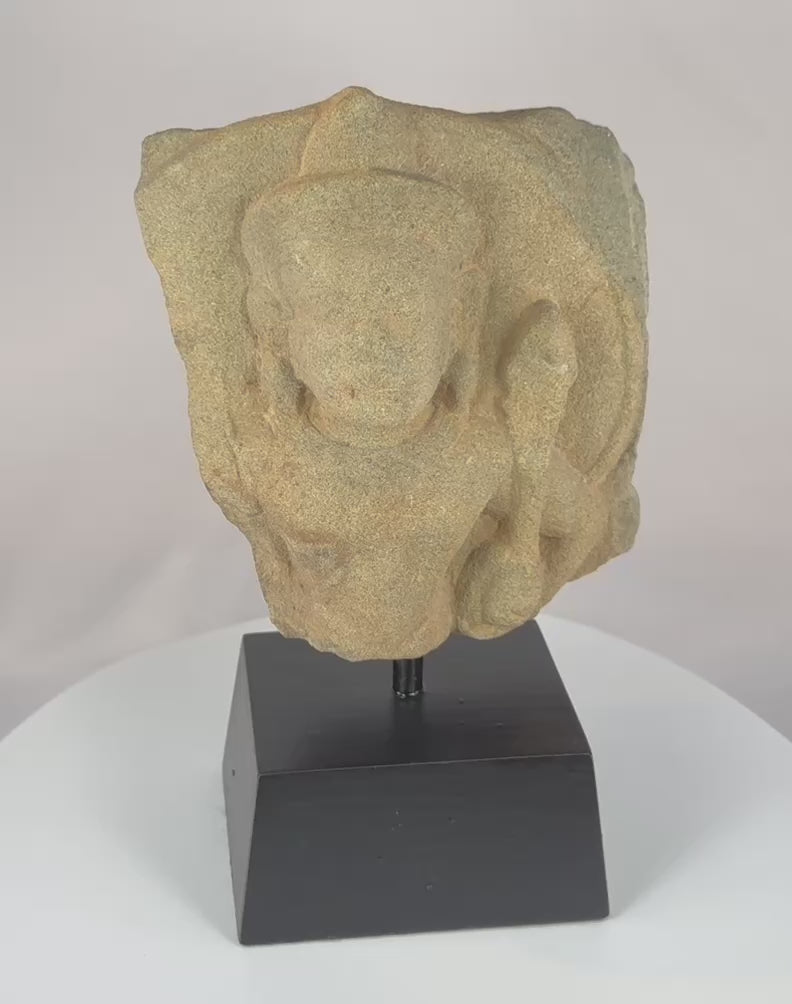 Video showing a 12th-century Khmer stone fragment depicting Padmapani Avalokitesvara from Cambodia, with serene facial features, refined Angkor-period carving, weathered stone surfaces, and preserved sculptural details associated with Buddhist devotional art.