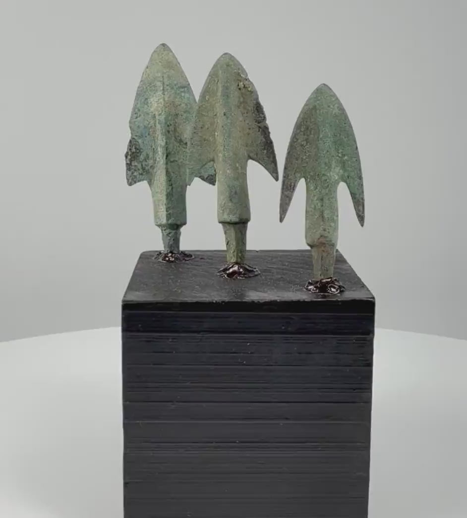 360-degree video of three ancient Iranian bronze projectile points from the Late Bronze to Early Iron Age, highlighting their lanceolate blades, raised midribs, flaring shoulders, and archaeological green patina.