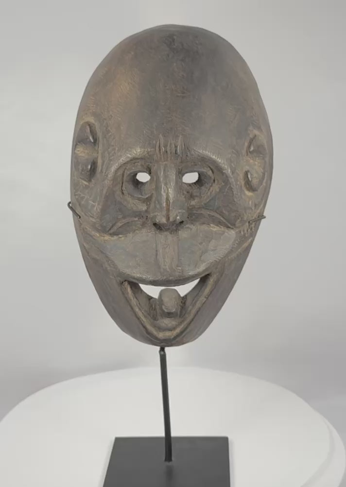 Rotating video of a West Timor ritual mask from Fatuleu Village, circa 1930, displaying traditional Atoni carving traditions, large pierced eyes, an open mouth with protruding tongue, and an aged hardwood surface.