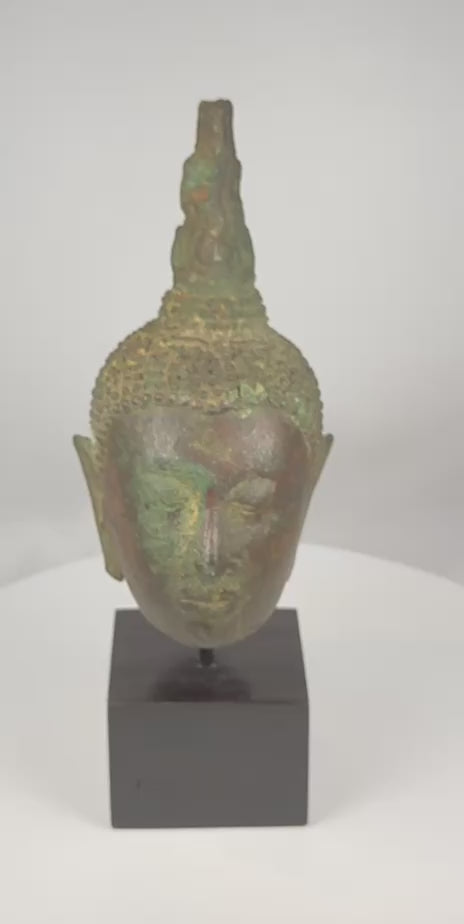 360-degree rotating video of a Sukhothai bronze Buddha head with flame finial and natural patina, circa 14th–15th century CE