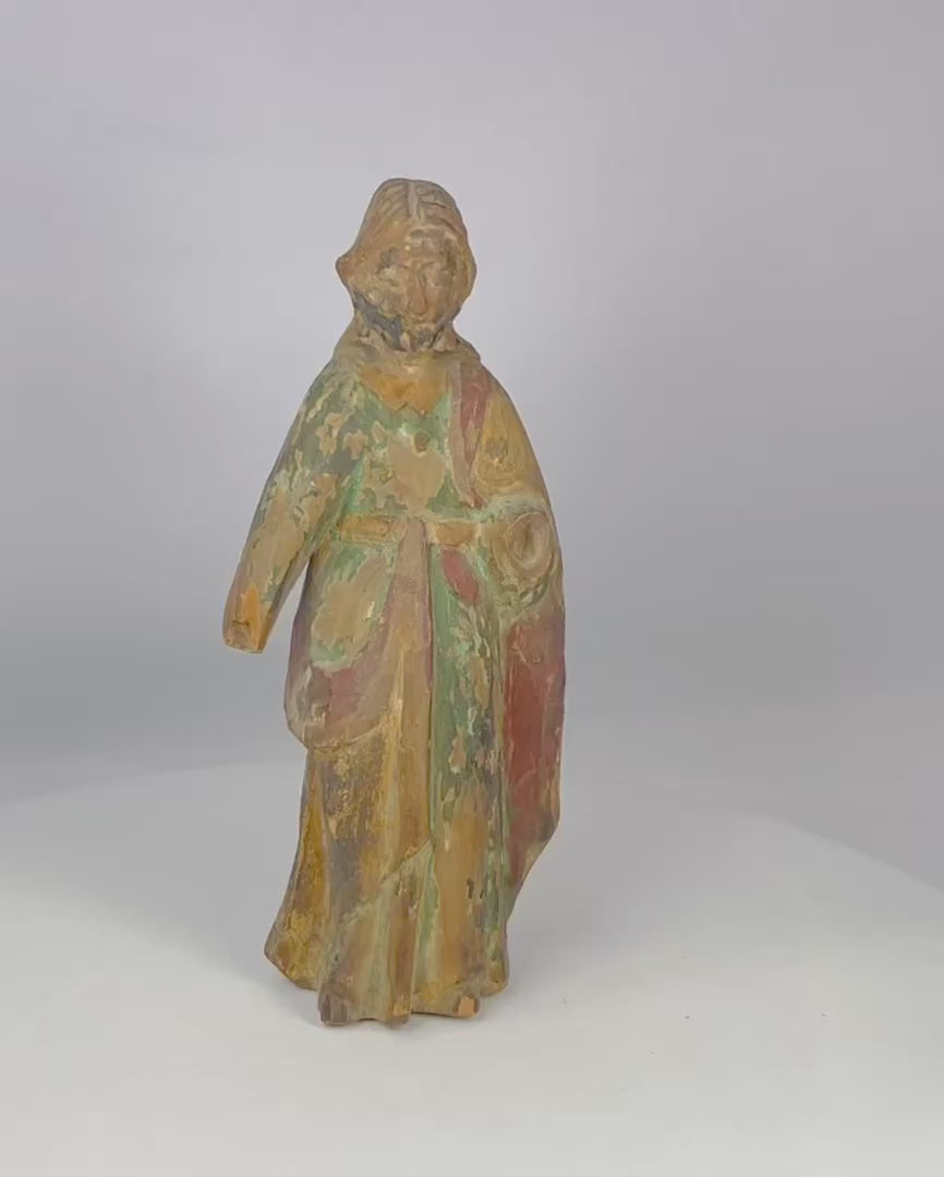 17th–18th century Spanish Colonial wooden statue of a saint or religious figure, hand-carved with flowing drapery and expressive face. Remnants of polychrome paint, surface wear, and a missing arm reflect centuries of devotional use in churches, chapels, or private altars, showcasing Colonial religious artistry.