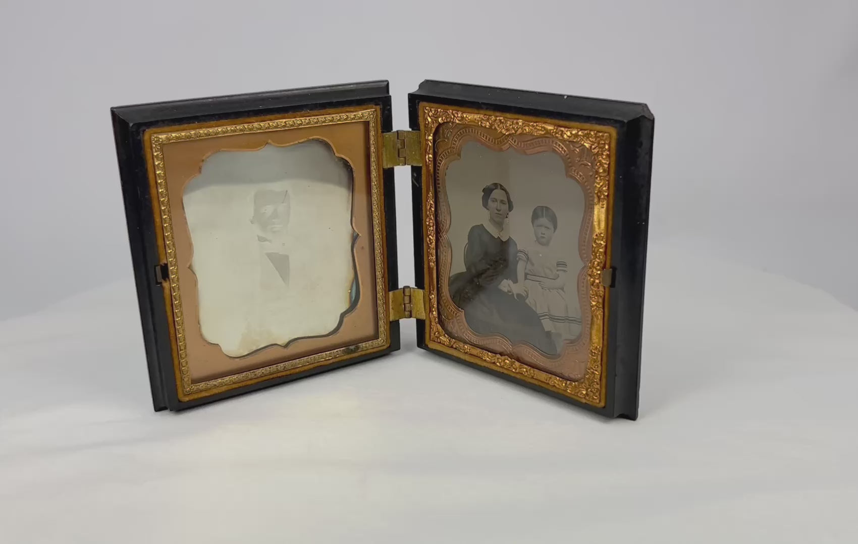 360° view of a Victorian-era daguerreotype keepsake case featuring dual portraits displayed open on a white background