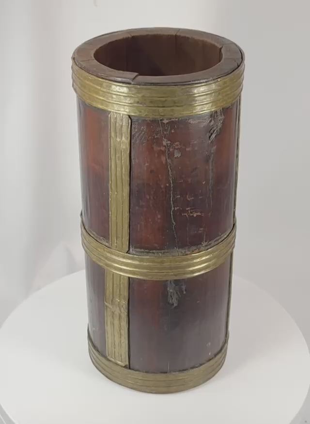 360-degree rotating view of an antique Tibetan storage vessel constructed from dark hardwood staves and reinforced with hand-worked brass bands and vertical brass strips. A traditional Himalayan container used for storing grains, tea, butter, and household goods, displaying rich aged patina and authentic signs of long-term use.