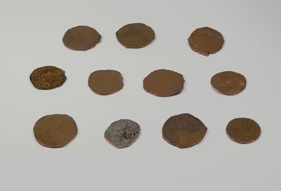 Video showcasing eleven medieval Crusader-era copper-alloy coins from circa 11th–13th century CE, highlighting their irregular shapes, worn inscriptions, historical designs, and naturally aged patination.