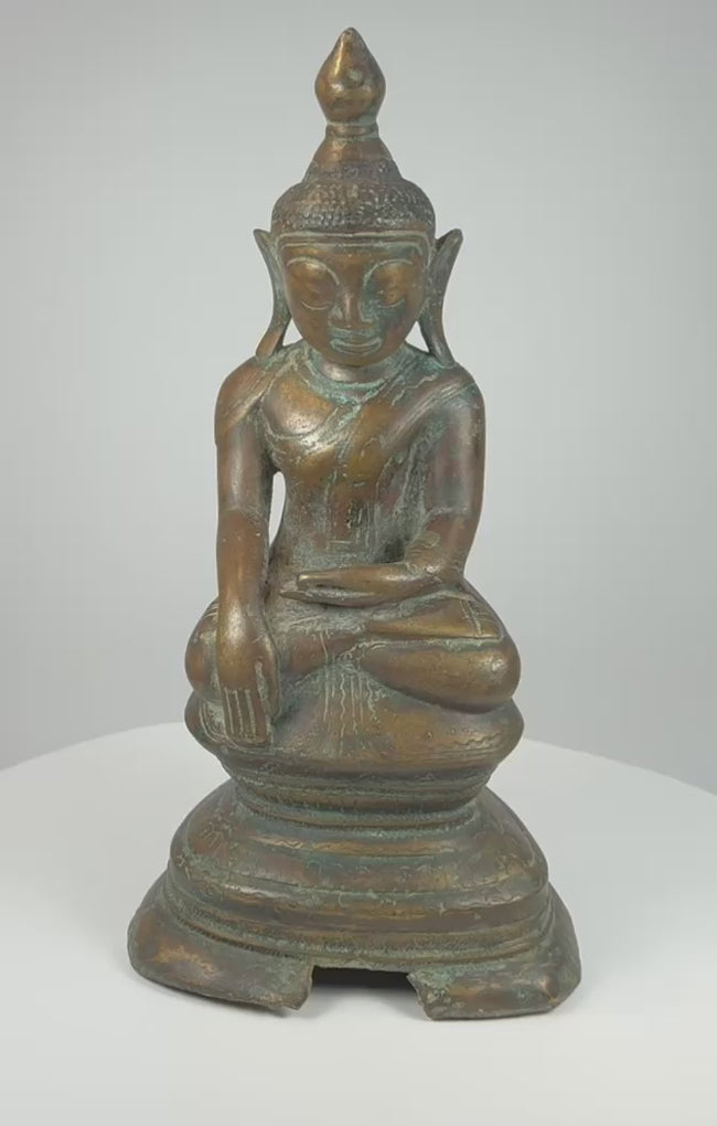 360-degree video of an antique Konbaung Period Burmese bronze Buddha showing the earth-touching gesture, lotus throne, aged patina, pedestal, and open underside