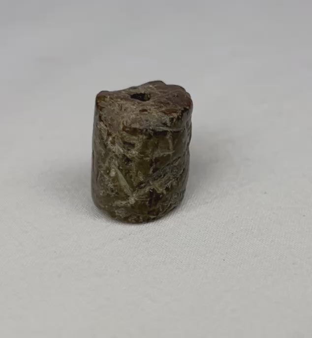 Video of hand-carved Egyptian stone amulet featuring stylized snake designs and weathered ancient surface