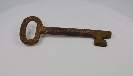 18th-century European forged iron skeleton key with oval bow, wedge-shaped ward, and developed patina, used for warded locks in manors, castles, or estates.
