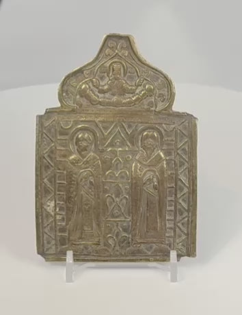 Rotating view of an antique Russian Orthodox bronze travel icon panel depicting Saints Blaise and Athanasius beneath Christ enthroned, showing detailed casting, Church Slavonic inscriptions, decorative ornamentation, and aged patina dating to the Russian Empire, circa 1850–1890.