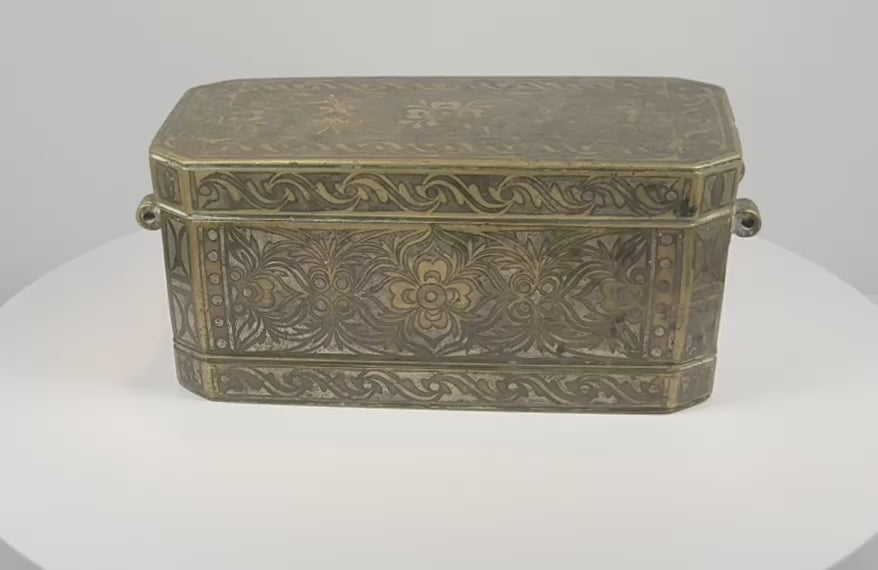 Rotating 360-degree video of an antique Philippine betel nut box, circa 1780–1820, showing its brass-inlaid exterior, engraved floral decoration, side rings, and fitted interior compartments.