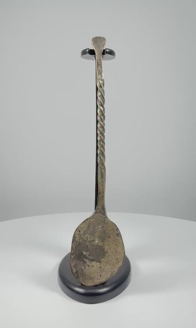 Video showcasing an ancient Roman bronze spoon from circa 2nd century AD, highlighting its spiral-twisted handle, shallow oval bowl, and natural green and brown patina.