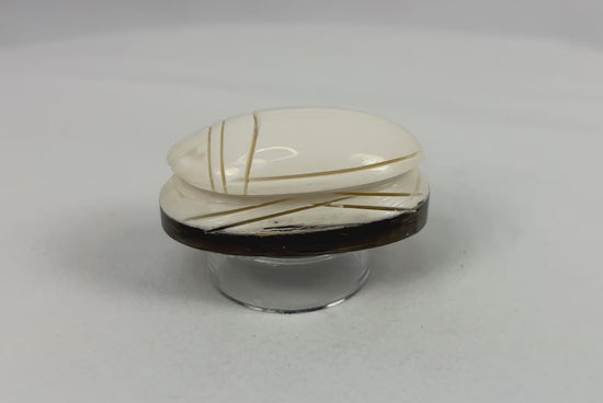 Rotating video of an East Asian hand-carved scarab-form talisman displayed on a dark oval base.