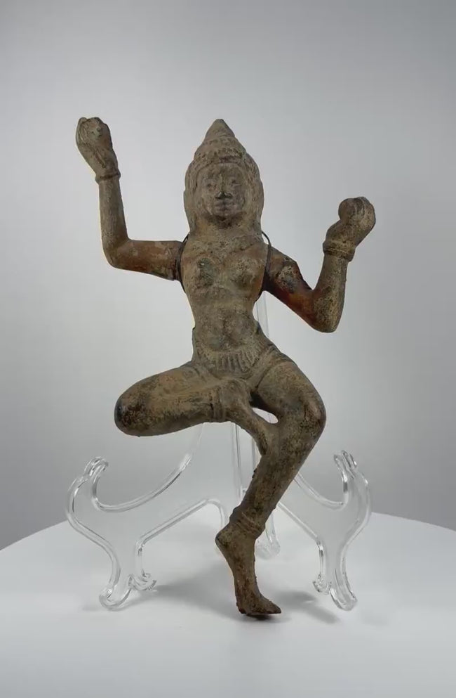Antique South Asian bronze dancing deity sculpture dating to circa 12th–18th century CE, featuring a graceful dancing posture, serene facial features, an ornate headpiece, flowing ceremonial attire, intricate ornamentation, and naturally aged green patina.