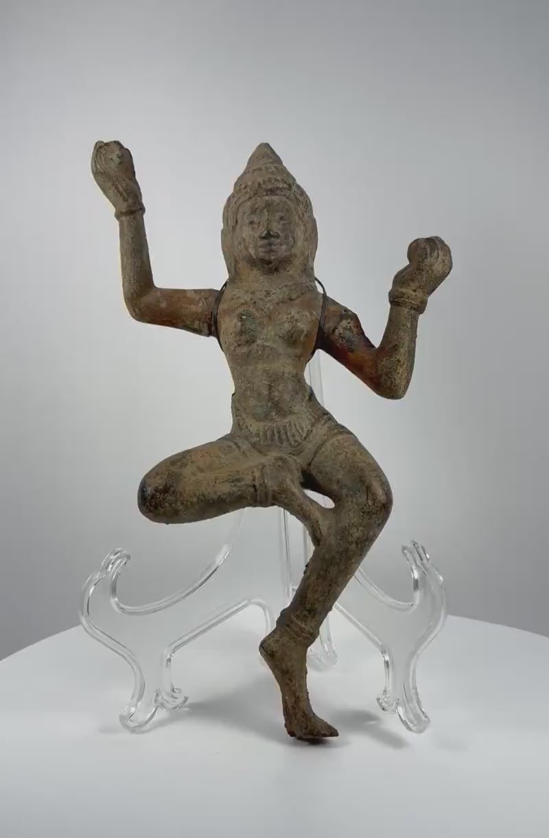 Antique South Asian bronze dancing deity sculpture dating to circa 12th–18th century CE, featuring a graceful dancing posture, serene facial features, an ornate headpiece, flowing ceremonial attire, intricate ornamentation, and naturally aged green patina.