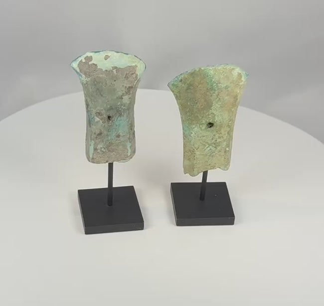 Video of two ancient Dong Son bronze socketed axe heads with flaring blades, hafting apertures, and archaeological patina