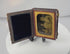 Rotating view of a quarter-plate Victorian Rehn ambrotype depicting three female sitters in period dress, housed behind a gilt brass mat in its original velvet-lined leatherette case