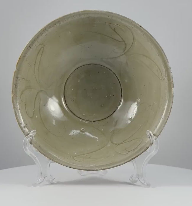 360-degree video of a Song dynasty celadon bowl from Fujian, China, circa the 12th century, showing its pale green glaze, incised floral decoration, and rounded form.